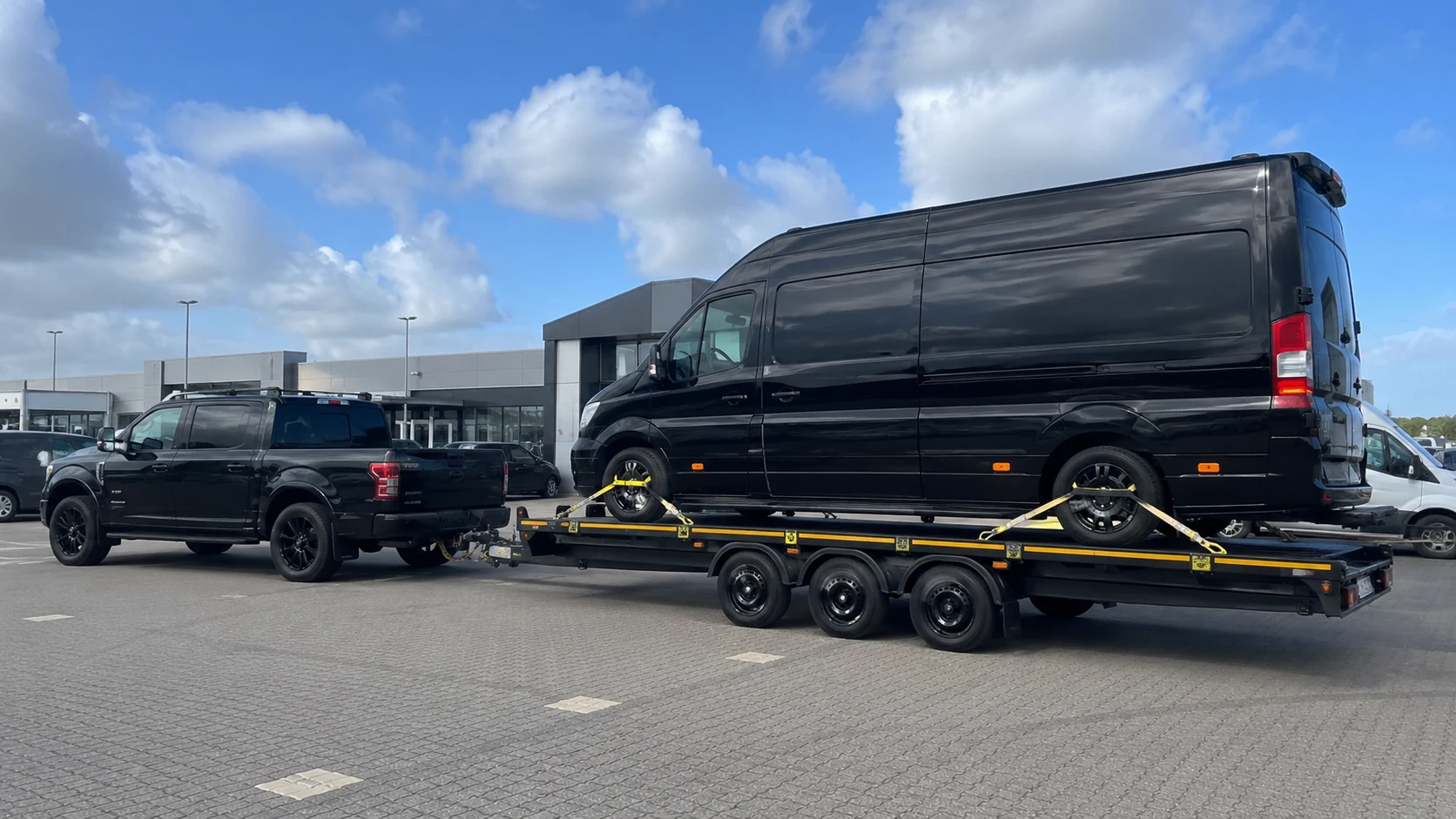 Large van secured on a tri-axle vehicle transporter